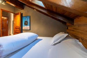 埃尔塔特Pleta del Tarter Lodge的卧室内的一张大白色床,设有阁楼