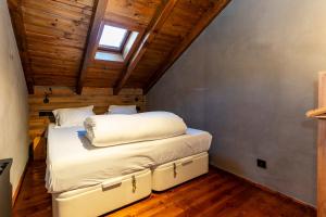 埃尔塔特Pleta del Tarter Lodge的拥有拱形天花板的客房内的一张床位