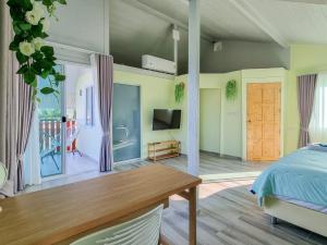 罗勇Tina's Living Paradise II - Guesthouses with private pool, 5 min to beach的一间卧室配有一张床、一张桌子和一台电视。