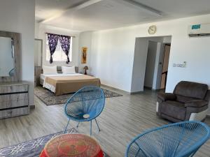 布韦朱Mjanaheri Beach Villas的一间卧室配有一张床、两把椅子和一张沙发