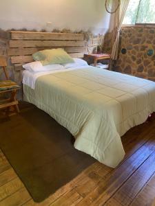 奥兰太坦波Cabaña del viajero.的一间卧室配有一张大床和木制床头板
