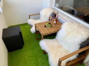 达沃斯WEF DAVOS PLATZ Centre 3,5 Apartment with Garage的客厅配有白色的毛绒椅子和桌子