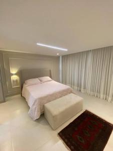 卡贝德卢Bangalô na praia的一间白色卧室,配有床和地毯