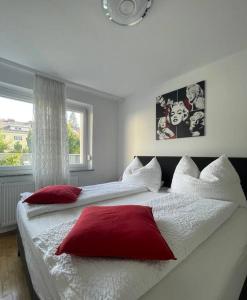 格蒙登Wohnung See- und Bergnähe的一间卧室配有两张带红白色枕头的床