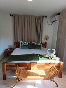 拉迪格岛Lucy's guesthouse的一间卧室配有一张床和一张鲜花桌子