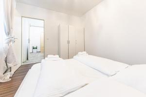 维也纳CENTRAL & AFFORDABLE by JR City Apartments的白色的客房设有三张床和镜子