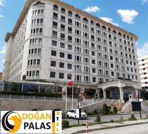 伊斯坦布尔Doğan Palace Hotel的前面有标志的大型白色建筑