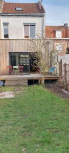 里尔Maison avec jardin à Lille Bois Blancs的庭院中带木甲板的房子