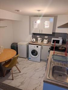 奥尔德姆1 Bedroom Flat Available的厨房配有水槽和洗衣机
