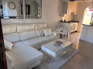 米哈斯科斯塔Adosado en residencial的客厅配有白色的沙发和桌子