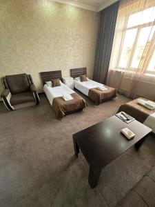 久姆里Olympic Hotel的客厅配有两张床和茶几