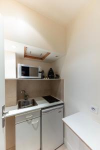 巴黎Studio sur les Quais de Seine的小厨房配有白色橱柜和水槽