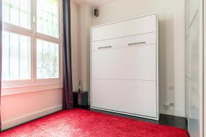 巴黎Studio sur les Quais de Seine的白色衣柜,有红色地毯和窗户