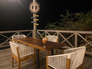 CamaronesMar Azul - Playa y Turismo的夜间甲板上的木桌和椅子