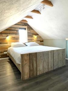 De VechtHet Zwaluwnest的一间卧室设有一张带木墙的大床