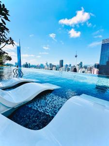 吉隆坡AXON RESIDENCE AT BUKIT BiNTANG KUALA LAMPUR的一座以城市天际线为背景的无边泳池