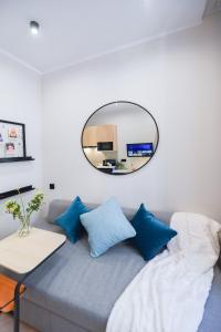 卡托维兹Apartament Plebiscytowa 32的一张带蓝色枕头的沙发上方的圆形镜子