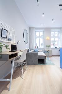 卡托维兹Apartament Plebiscytowa 32的白色的客厅配有书桌和床。
