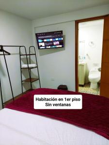 菲兰迪亚Hotel Casa Helena的卧室配有一张床铺,墙上配有电视