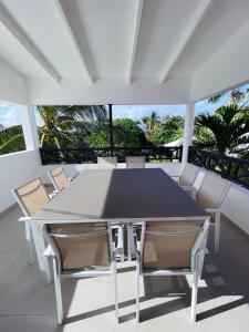哥西尔Emeraude Bay, Magnifique T3 Vue Mer proche de la plage的阳台上配有白色的桌椅