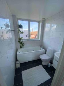 BrokindVackert boende med utsikt över fantastisk golfbana的带浴缸、卫生间和窗户的浴室