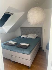 BrokindVackert boende med utsikt över fantastisk golfbana的一间卧室配有一张带蓝色床单和吊灯的床。