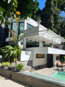 里约热内卢Maison Ruibal的一座白色的房子,前面设有一个游泳池