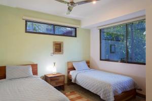 IguanaCasa Papaya - Eco Casita Phase 1-1的带2扇窗户的客房内的2张床
