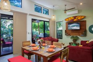 IguanaCasa Papaya - Eco Casita Phase 1-1的客厅配有木桌和红色椅子