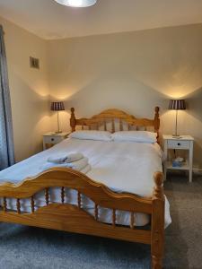 BallysheedyGreenview的一间卧室配有一张木床和两盏灯。