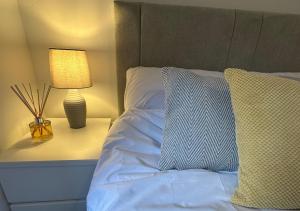 格拉斯哥Trendy West End Apartment, Glasgow的一间卧室配有一张带台灯和枕头的床
