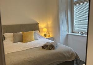 格拉斯哥Trendy West End Apartment, Glasgow的一间卧室配有一张床,上面有两条毛巾