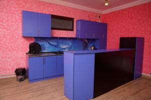迪利然Royal Rest Townhouse的厨房配有蓝色橱柜和紫色台面