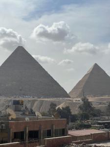 开罗The Home Boutique Hotel Pyramids Inn的从建筑中欣赏到吉萨金字塔的景色