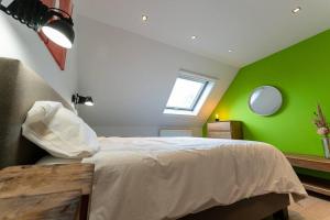 隆德泽尔Wit Peerd Guesthouse的一间卧室配有一张带绿色墙壁的床