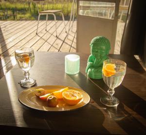 梅塞德斯Uy - Cabaña de ESTILO, entorno Natural ùnico的坐在桌子上的绿色雕像,上面有橙子