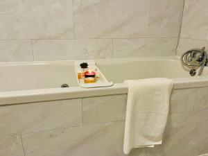 北希尔兹Glamorous Palace with spa bath的带浴缸和蜡烛托盘的浴室