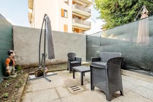 科尔西科A.P. Appartamento o camera的一个带椅子和遮阳伞的庭院,毗邻一个围栏