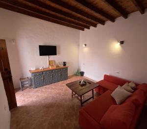 罗萨里奥港Casa Rural Muchichafe的客厅配有红色的沙发和桌子