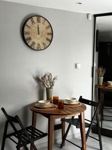 库尔迪加Vizbulu Holiday Home的餐桌,墙上挂着时钟