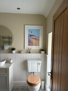 NorthamApplestow Cottage的一间带卫生间和木座椅的浴室