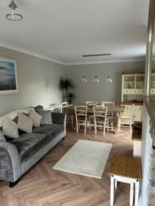 NorthamApplestow Cottage的带沙发的客厅和用餐室