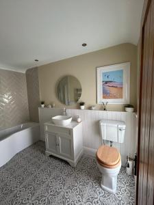 NorthamApplestow Cottage的浴室配有盥洗盆、卫生间和浴缸。