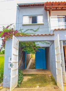 卡兰卡斯Casa Da Cléo Carrancas的一间蓝色的房子,设有开放式门和走廊