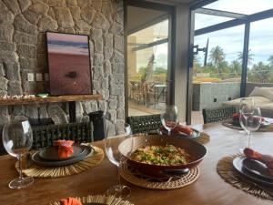 圣米格尔-杜斯米拉格里斯Kanui Mar (cobertura garden)的餐桌,放着一碗食物和酒杯