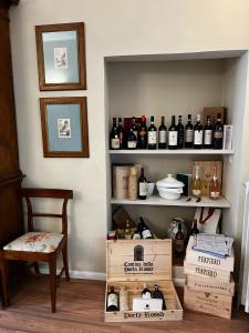 波吉邦西Maestra Exclusive Chianti House, Tuscany的一间设有书架、葡萄酒和椅子的房间