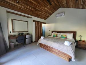 波特雷罗Villas Pura Vibra的一间卧室设有一张带木制天花板的大床