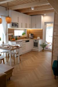 Pod Kalwarią的厨房铺有木地板,配有白色橱柜。