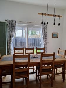 基拉尼Rose Cottage的一间带木桌和椅子的用餐室