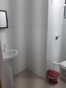 马蒂尼奥斯Pousada Belaisa的白色的浴室设有卫生间和水槽。